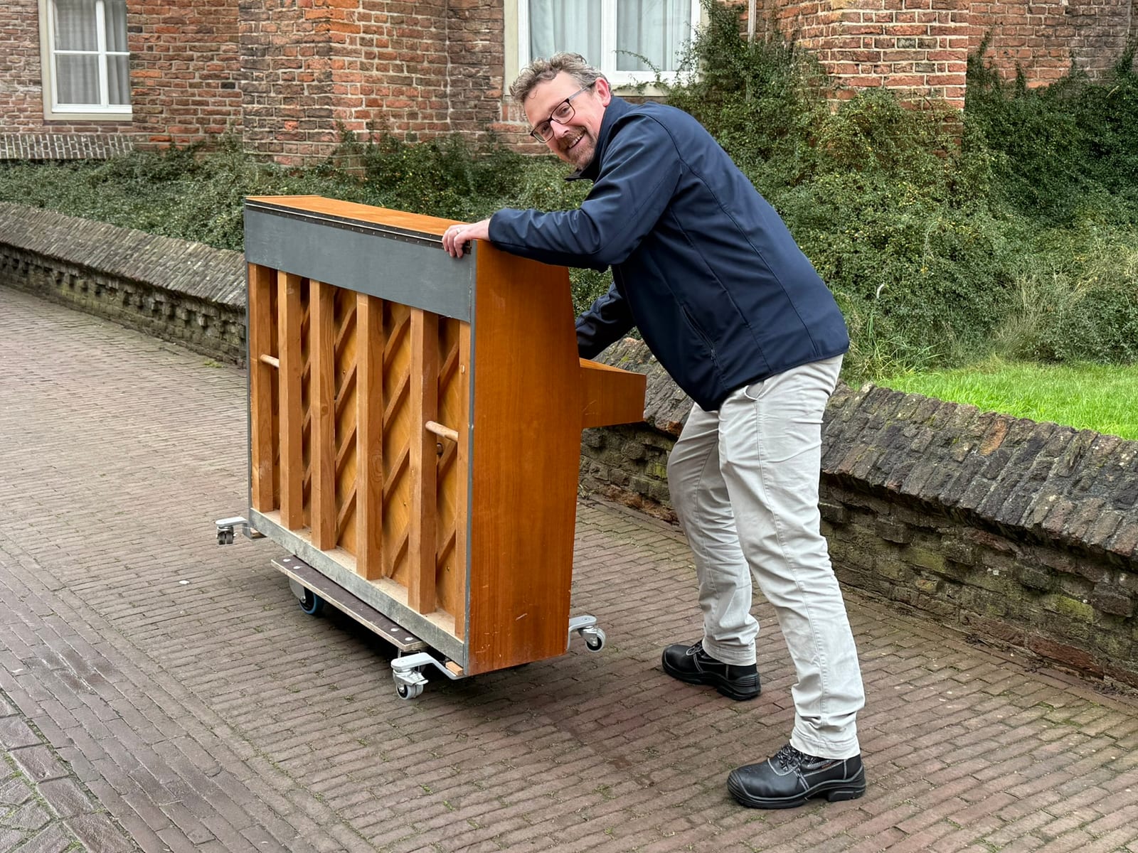 Elmar wandelt met een piano op straat.